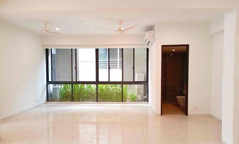 Empty apartment space with large window and wooden door